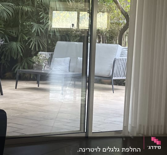 חלון זכוכית עם תריסים פתוחים חלקית